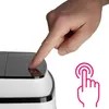 A hand is pressing a button on a black and white electronic device. Náhled obrázku produktu