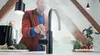 A man in a kitchen is using a Quooker tap that is dispensing hot water, with steam rising from it. There are vegetables on the counter. Anteprima dell’immagine prodotto