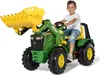 A young boy is riding a green and yellow toy tractor with a front loader. Produktbild-Vorschau