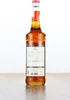 A bottle of Monin Caramel Syrup is shown against a white background, standing on a wooden surface. Produktbild-Vorschau