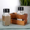 A salt and pepper shaker set in a wooden holder, placed on a green cloth. Náhľad obrázku produktu