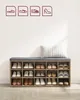 A shoe storage bench with a cushion and several pairs of shoes inside, against a white wall. Náhled obrázku produktu