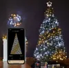 A Christmas tree decorated with lights, a wreath on the wall, and a smartphone displaying a light pattern. Náhled obrázku produktu