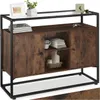 A sideboard with a rustic wood finish and black metal frame, displayed in a studio setting with decorative items on top. Náhled obrázku produktu
