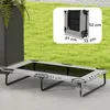A raised dog bed is shown outdoors on a patio, with a grassy area and a planter in the background. A smaller inset image shows the folded dimensions of the bed. Produktbild-Vorschau