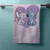 A towel with Stitch and Angel characters printed on it, hanging on a towel rack. Produktbild-Vorschau