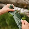 Hands holding and tearing a green plastic bag from a roll. Anteprima dell’immagine prodotto