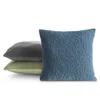 Three fluffy pillows are stacked on a white background. The front pillow is blue, the middle pillow is gray, and the bottom pillow is green. Voir les images du produit