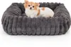 A small dog sitting in a plush dog bed. Produktbild-Vorschau