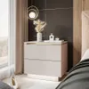 A modern bedroom scene featuring a nightstand with decorative items and a bed in the background. Produktbild-Vorschau