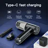 A black cordless handheld vacuum cleaner is shown with its accessories and charging cable connected to a power strip. The background features text and icons indicating charging options. Produktbild-Vorschau