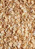 A close-up, overhead view of a pile of fine leaf spelt flakes. Produktbild-Vorschau