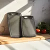 Two gray cutting boards are placed on a wooden cutting board, with tomatoes and parsley in the background. Anteprima dell’immagine prodotto
