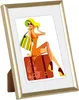 A framed illustration of a woman sitting on a suitcase, ready for travel. Produktbild-Vorschau