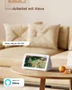 A smart display showing a live feed from an outdoor camera, placed on a coffee table in a living room. Produktbild-Vorschau