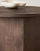 A close-up view of a dark brown wooden table with a white bowl on top. Produktbild-Vorschau