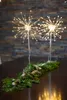 Two LED firework lights are placed on a table runner made of greenery and pinecones. Produktbild-Vorschau