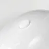 A close-up view of a white, oval-shaped button on a curved white surface. Produktbild-Vorschau