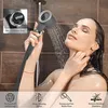A woman is taking a shower with a handheld showerhead. Anteprima dell’immagine prodotto