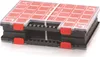 A black and red plastic organizer box with multiple compartments and a clear lid, secured with white elastic bands. Produktbild-Vorschau