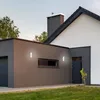 Exterior view of a modern house with a garage and entrance, featuring outdoor lighting. Produktbild-Vorschau