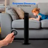 A hand holds a remote control in the foreground, with a black tower fan and a child lying on a sofa in the background. Produktbild-Vorschau