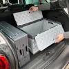 A person is placing foldable storage boxes into the trunk of a car. Produktbild-Vorschau