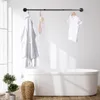 A bathroom scene with a bathtub, clothing rack, and plants. Produktbild-Vorschau