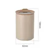 A product shot of a beige ceramic storage container with a brown lid, featuring dimensions indicated by measurement lines and text. Produktbild-Vorschau