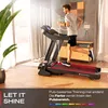A man is running on a treadmill in a modern living room. Produktbild-Vorschau