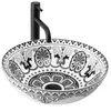 A black faucet is mounted behind a decorative ceramic sink. Náhled obrázku produktu