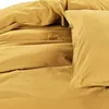 A close-up view of folded yellow bedding, showing the texture and folds of the fabric. Produktbild-Vorschau
