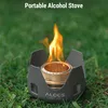 A portable alcohol stove with flames burning, set on grass. Produktbild-Vorschau