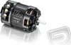 A black brushless motor with silver accents and gold windings, shown on a reflective white surface. Produktbild-Vorschau