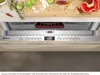 A close-up view of a dishwasher's control panel and the top rack, with food items visible on a cutting board in the background. Produktbild-Vorschau