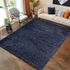 A living room scene with a navy blue rug in the foreground, a white sofa with cushions, and a chair. Produktbild-Vorschau