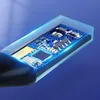 A close-up view of a transparent USB audio adapter, revealing its internal circuitry. Náhľad obrázku produktu