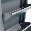 Close-up view of the interior of a grey metal shoe cabinet with multiple flip-down doors. Voir les images du produit