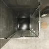 A top-down view of a modern shower cabin with glass doors and silver frames, set against dark gray tiled walls and a lighter tiled floor. Produktbild-Vorschau