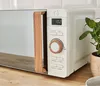 A close-up shot of a modern microwave with a wooden handle, placed on a wooden countertop. Anteprima dell’immagine prodotto