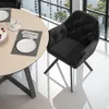 A dining chair and table setting in a modern interior with large windows. Voir les images du produit