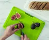 A person is cutting figs on a green cutting board, with sliced bread on a white cutting board in the background. Anteprima dell’immagine prodotto
