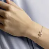 A woman's arm wearing a rose gold bracelet with a pink swan charm. Anteprima dell’immagine prodotto