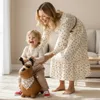 A mother and child playing with a ride-on toy dog in a living room. Produktbild-Vorschau