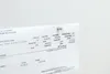 A close-up of a document, likely an invoice or receipt, pinned to a white surface. Náhľad obrázku produktu