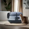 A cat sits next to a closed litter box in a well-lit room. Anteprima dell’immagine prodotto