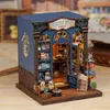 A miniature bookshop model with intricate details, displayed on a wooden surface. Náhled obrázku produktu