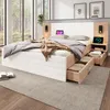 A modern bedroom with a large bed, nightstands, and a window overlooking a forest. Produktbild-Vorschau