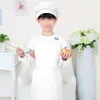 A child dressed as a chef holding a spoon and an apple. Produktbild-Vorschau