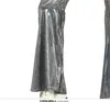 Close-up of the lower half of a person wearing shiny silver flared pants and white shoes. Produktbild-Vorschau